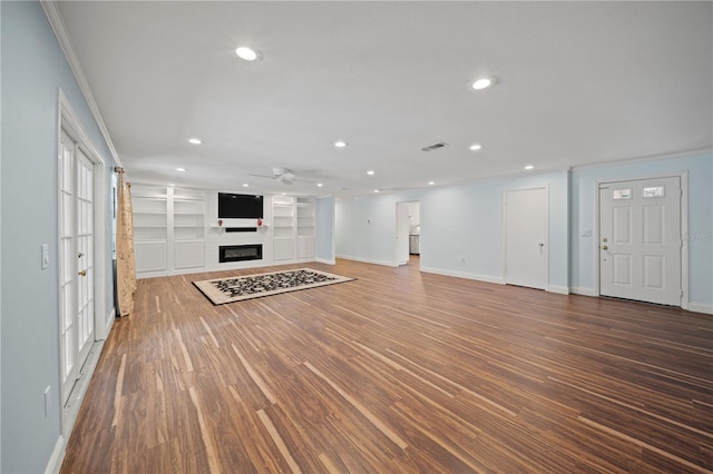 unfurnished living room with ceiling fan, wood-type flooring, built in features, and a large fireplace