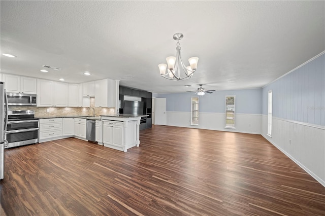 kitchen featuring white cabinetry, stainless steel appliances, decorative backsplash, sink, and kitchen peninsula