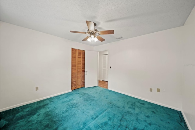 carpeted empty room featuring a textured ceiling and ceiling fan