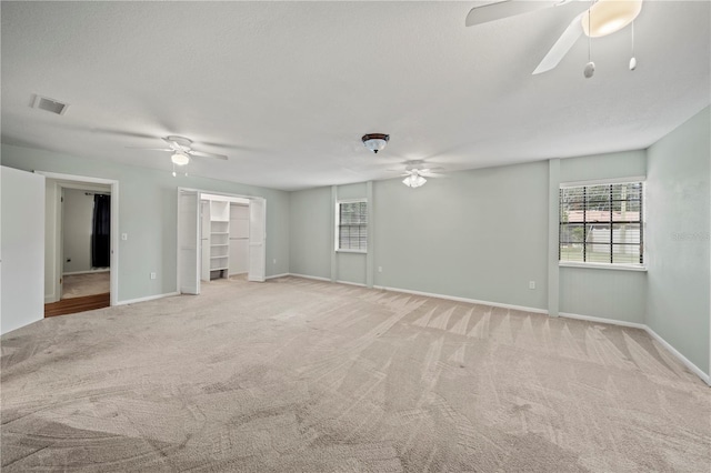 spare room with ceiling fan and light colored carpet