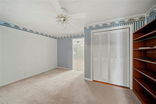 unfurnished bedroom featuring ceiling fan, light colored carpet, a closet, and a textured ceiling