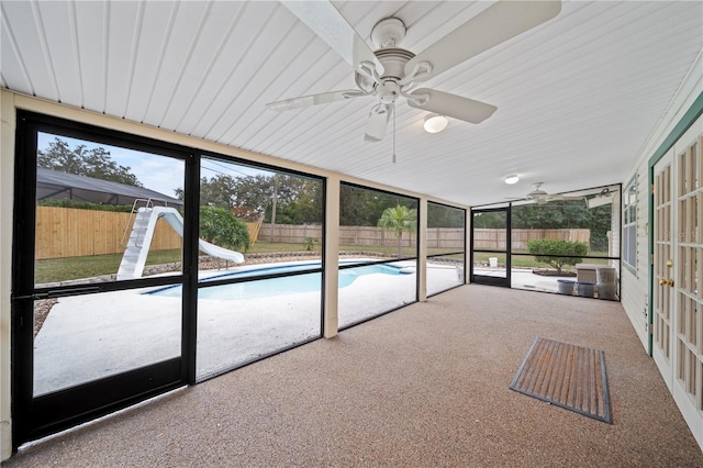 unfurnished sunroom with ceiling fan