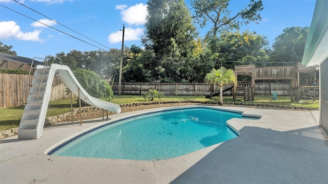 view of pool with a patio area, a water slide, and a playground