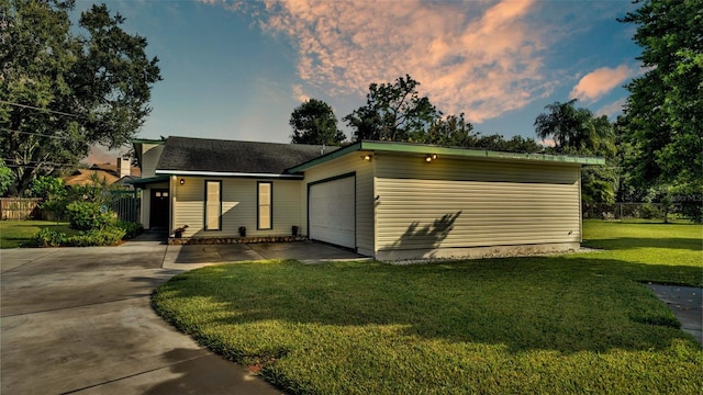 view of front of property with a garage and a lawn