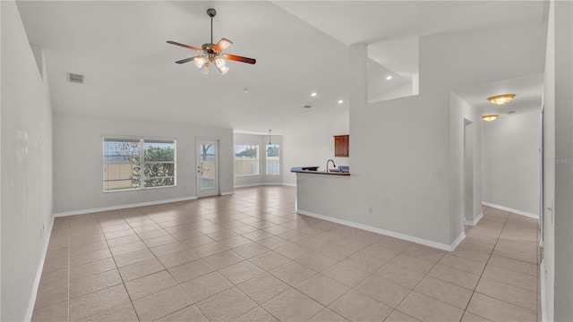 unfurnished living room with high vaulted ceiling, ceiling fan, and light tile patterned floors