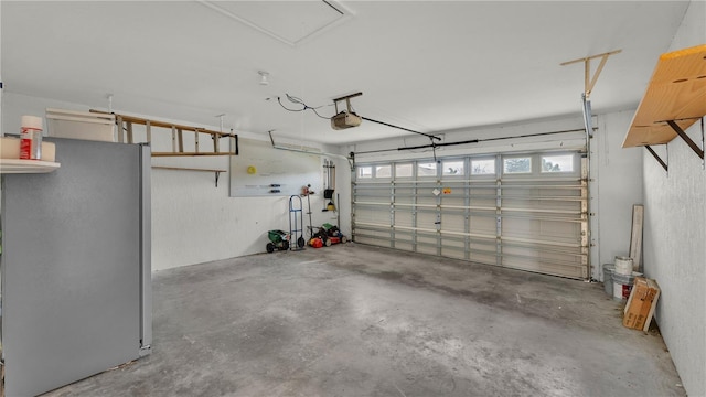 garage with a garage door opener and stainless steel refrigerator