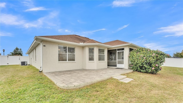 back of property featuring a lawn, central air condition unit, a sunroom, and a patio