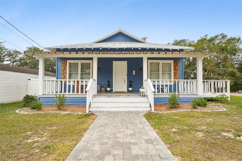 bungalow with a porch and a front lawn