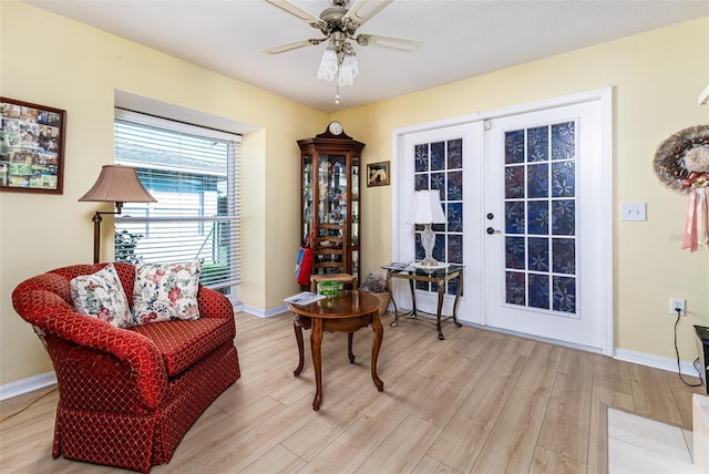 sitting room with light wood-style flooring, baseboards, and ceiling fan