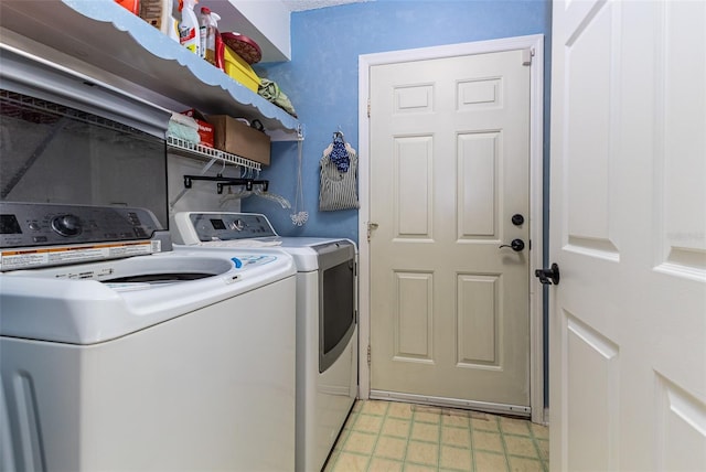 clothes washing area with washer and dryer, light floors, and laundry area