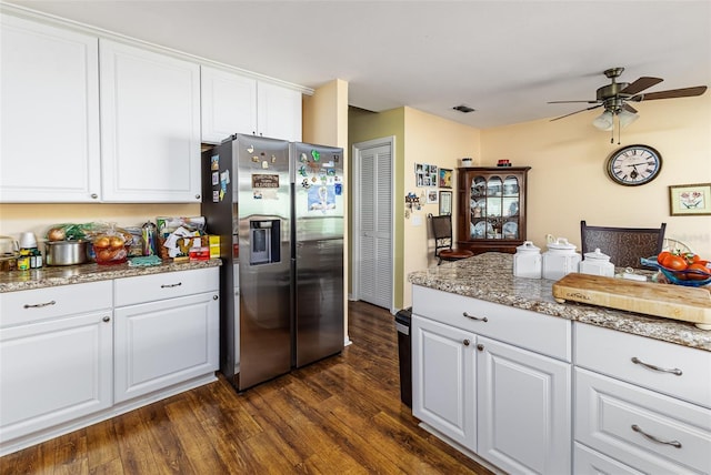 kitchen with visible vents, dark wood-style floors, stainless steel fridge, white cabinets, and ceiling fan