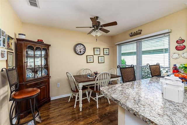 dining space featuring dark wood-style floors, a ceiling fan, visible vents, and baseboards