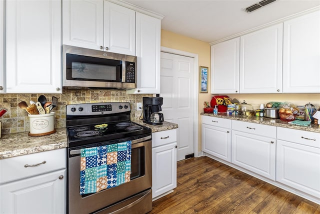 kitchen with visible vents, tasteful backsplash, stainless steel appliances, white cabinets, and dark wood-style flooring