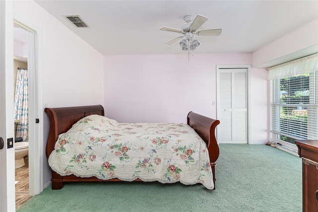 carpeted bedroom featuring visible vents, a closet, and a ceiling fan