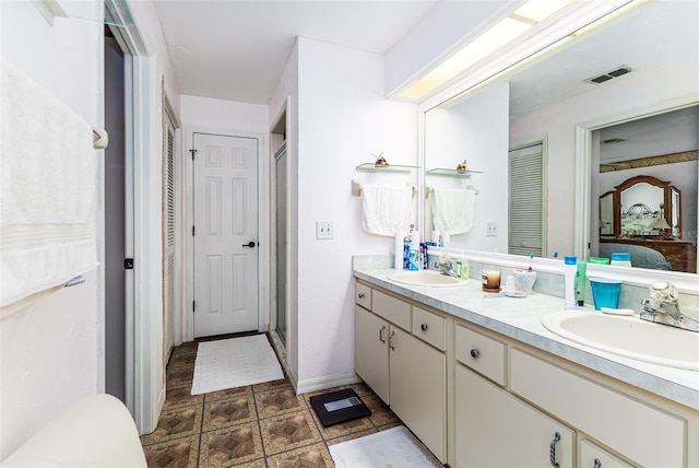 ensuite bathroom featuring double vanity, a stall shower, ensuite bath, and a sink