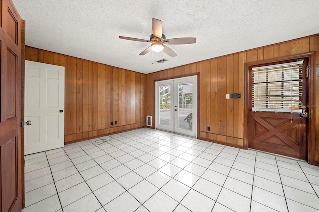 spare room featuring ceiling fan, a textured ceiling, light tile patterned floors, and french doors