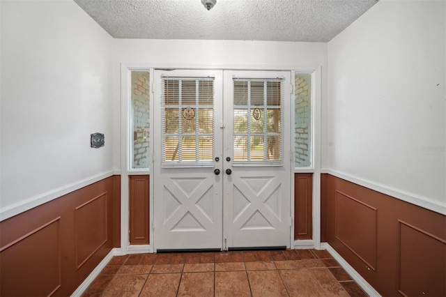 entryway featuring a textured ceiling and dark tile patterned floors