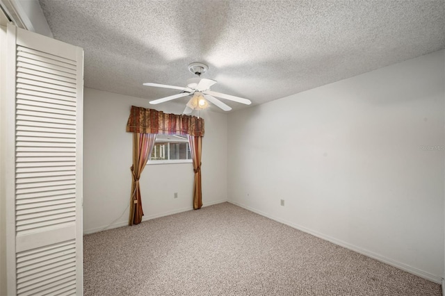 unfurnished bedroom with ceiling fan, carpet, and a textured ceiling