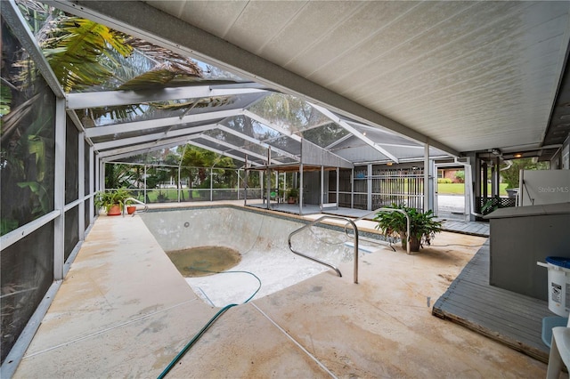 view of swimming pool featuring a patio and glass enclosure