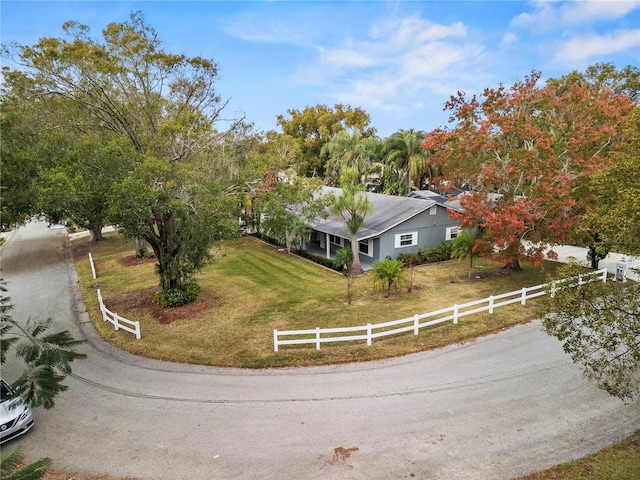 view of front of property featuring a front lawn and a rural view