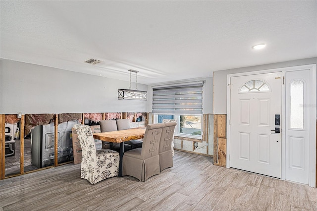 dining space featuring a textured ceiling and hardwood / wood-style floors