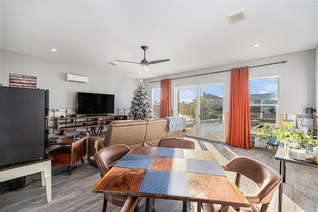 dining area with ceiling fan, light hardwood / wood-style flooring, and an AC wall unit