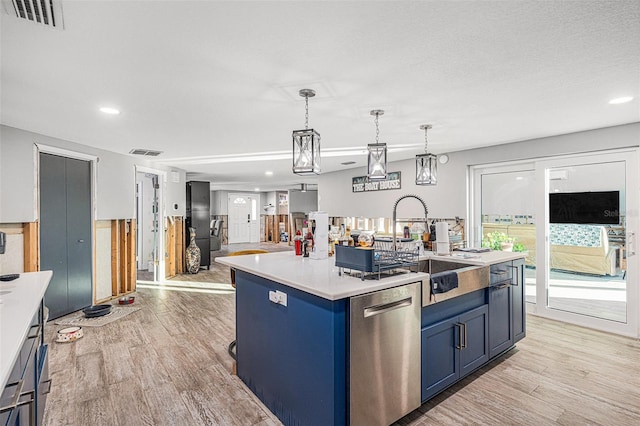 kitchen with blue cabinetry, hanging light fixtures, a kitchen island with sink, light wood-type flooring, and stainless steel dishwasher