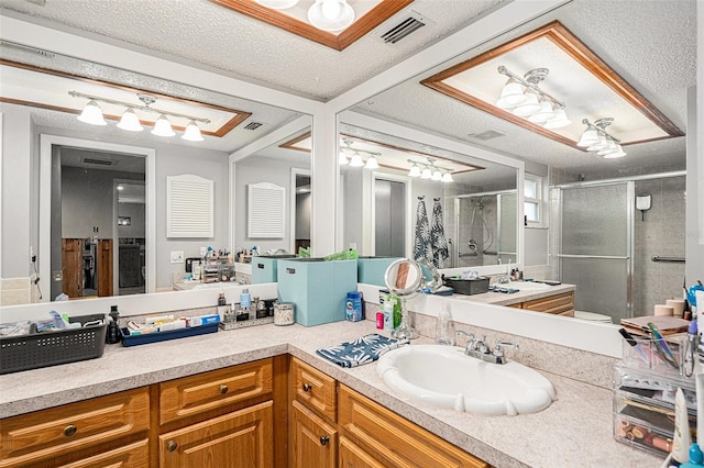 bathroom with vanity, a textured ceiling, and an enclosed shower