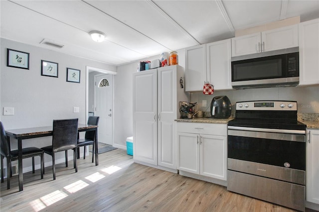 kitchen featuring light stone counters, stainless steel appliances, white cabinets, and light hardwood / wood-style flooring