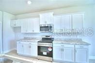 kitchen with white cabinets and appliances with stainless steel finishes