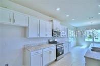 kitchen featuring white cabinetry and stainless steel electric stove