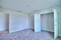 unfurnished bedroom with a closet and dark carpet