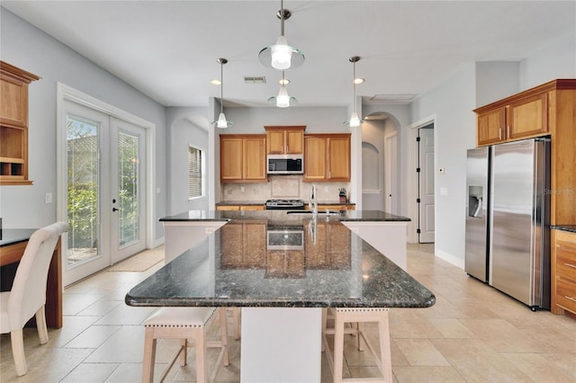 kitchen with a spacious island, appliances with stainless steel finishes, a kitchen breakfast bar, and hanging light fixtures