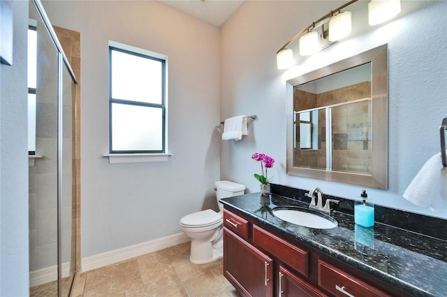 bathroom with a shower with door, vanity, and toilet