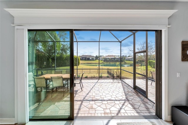 doorway to outside featuring a water view and a healthy amount of sunlight