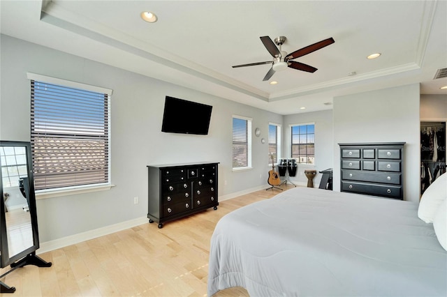 bedroom with a raised ceiling, ceiling fan, crown molding, and light wood-type flooring