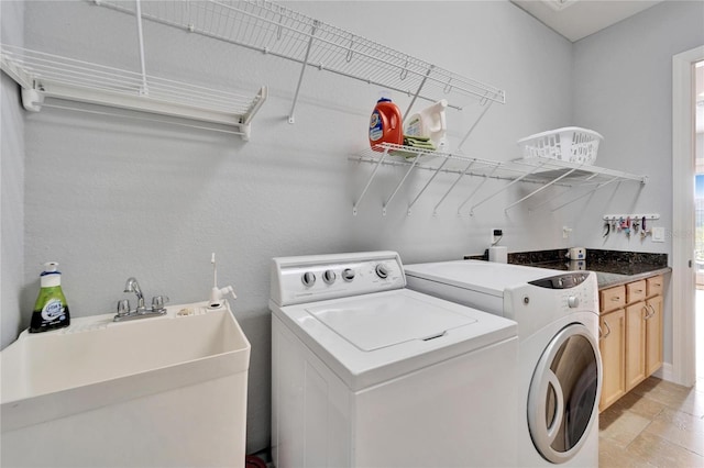 clothes washing area featuring sink and washer and clothes dryer