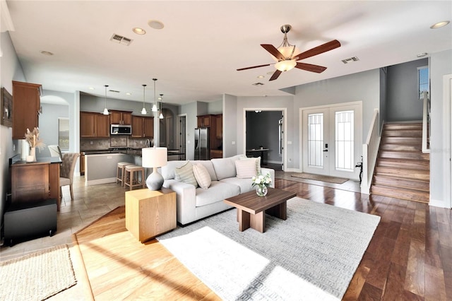 living room featuring dark hardwood / wood-style floors, ceiling fan, and french doors