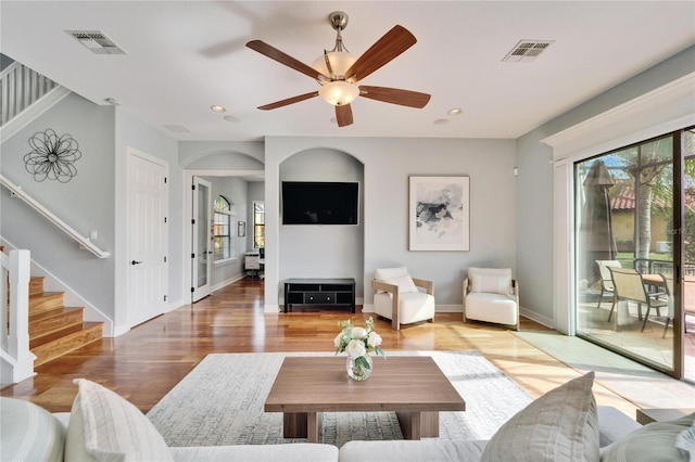 living room featuring wood-type flooring, a wealth of natural light, and ceiling fan