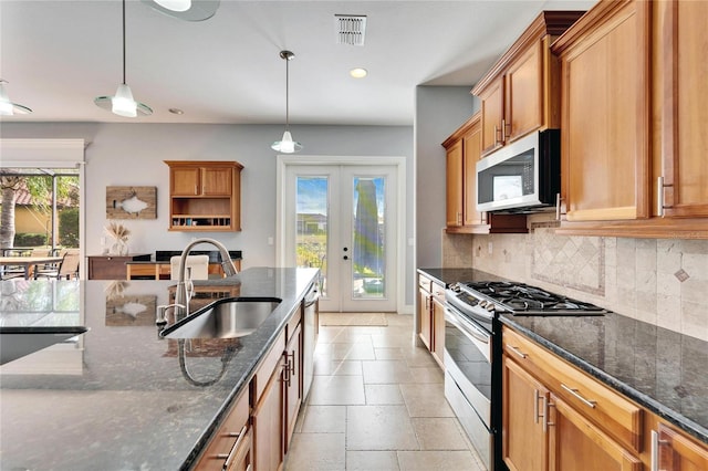 kitchen with sink, stainless steel appliances, hanging light fixtures, and french doors