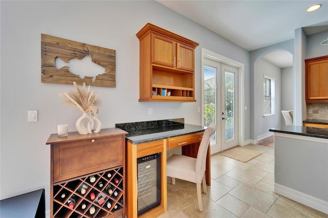 kitchen with wine cooler and dark stone countertops