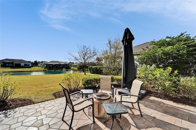 view of patio with an outdoor fire pit and a water view