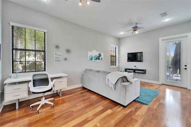 living room with ceiling fan and light wood-type flooring