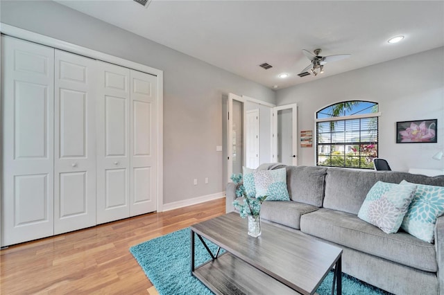 living room with wood-type flooring and ceiling fan