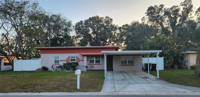 ranch-style house featuring a yard and a carport