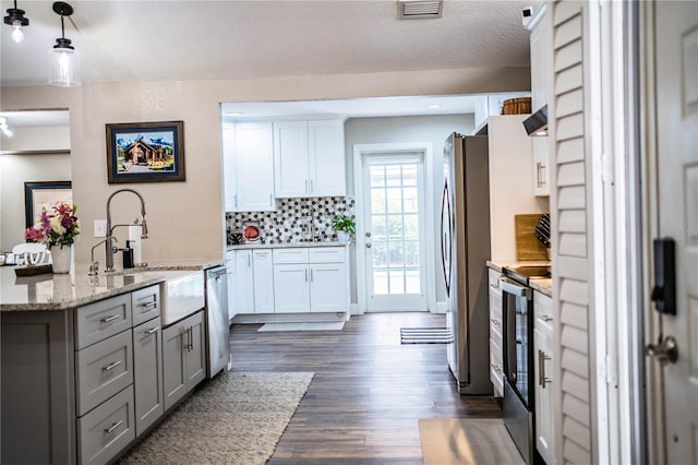 kitchen featuring white cabinetry, pendant lighting, tasteful backsplash, and light stone countertops