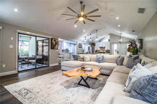 living room with vaulted ceiling, dark hardwood / wood-style flooring, and ceiling fan with notable chandelier