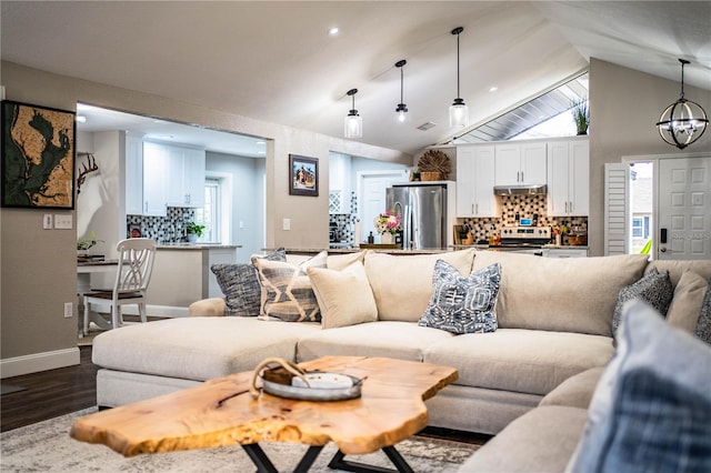 living room featuring lofted ceiling, dark hardwood / wood-style floors, and an inviting chandelier