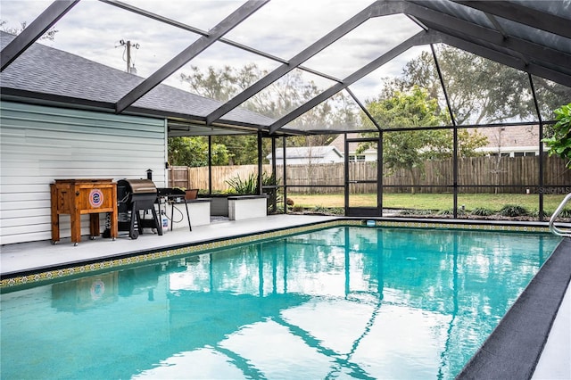 view of pool with a lanai, a grill, and a patio