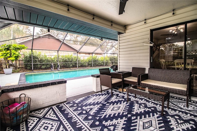 view of swimming pool featuring ceiling fan, glass enclosure, outdoor lounge area, and a patio